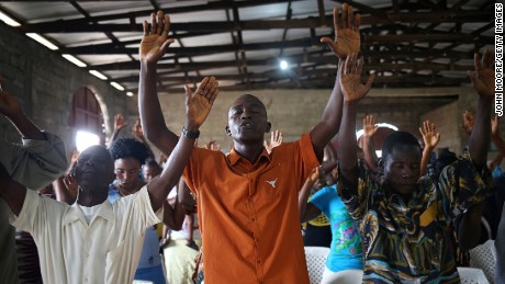 Church members pray during a Sunday service at a church in Dolo Town, Liberia, on August 24, 2014.