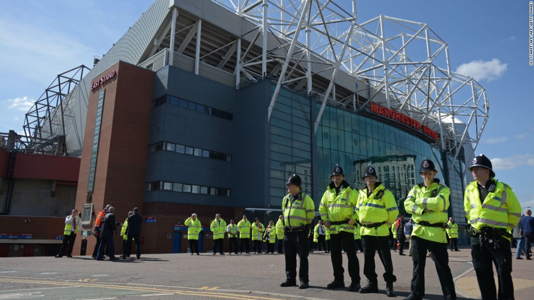 Police officers stand on duty outside Old Trafford stadium after the English Premier League football match between Manchester United and Bournemouth was abandoned Sunday.