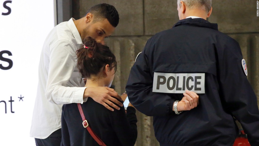A relative is escorted at Paris&#39; Charles de Gaulle Airport. 