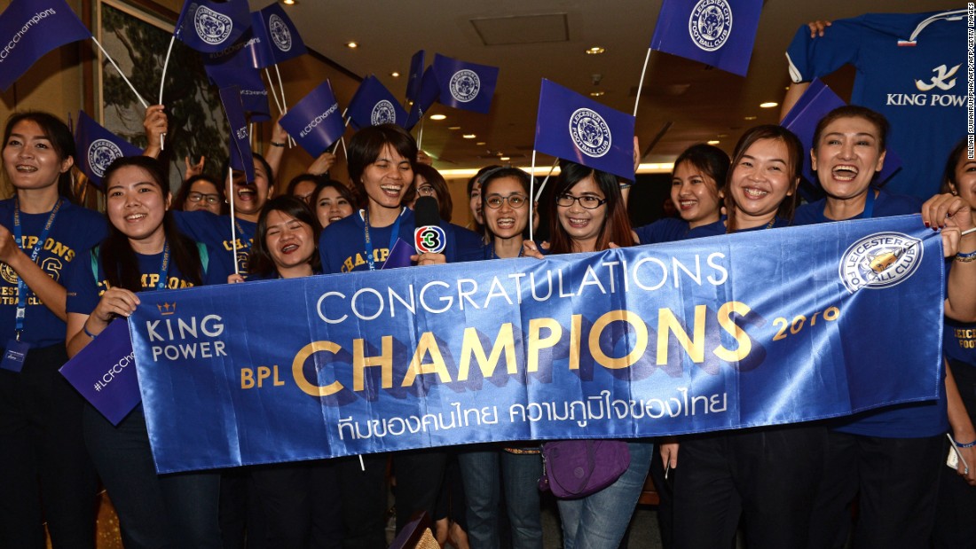Leicester City&#39;s jubilant players and staff are greeted by a banner of congratulations as they arrive in Thailand.