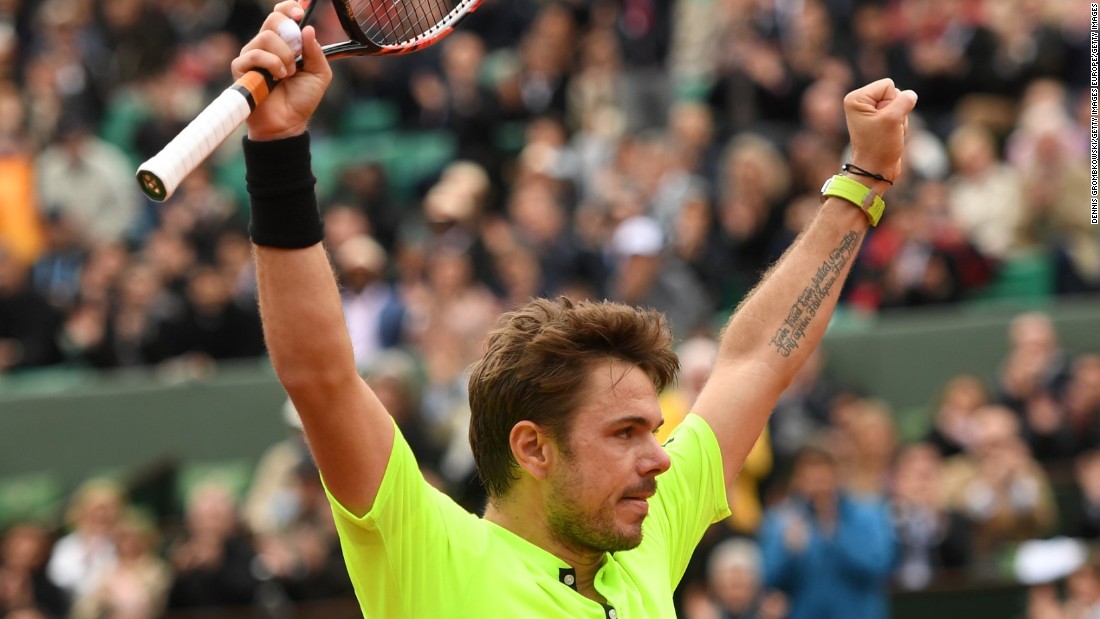 Stan Wawrinka raises his arms in celebration after seeing off Lukas Rosol in five sets in the first round. 