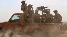 TOPSHOT - Armed men in uniform identified by Syrian Democratic forces as US special operations forces ride in the back of a pickup truck in the village of Fatisah in the northern Syrian province of Raqa on May 25, 2016. 
US-backed Syrian fighters and Iraqi forces pressed twin assaults against the Islamic State group, in two of the most important ground offensives yet against the jihadists. The Syrian Democratic Forces (SDF), formed in October 2015, announced on May 24 its push for IS territory north of Raqa city, which is around 90 kilometres (55 miles) south of the Syrian-Turkish border and home to an estimated 300,000 people. The SDF is dominated by the Kurdish People's Protection Units (YPG) -- largely considered the most effective independent anti-IS force on the ground in Syria -- but it also includes Arab Muslim and Christian fighters.

 / AFP / DELIL SOULEIMAN        (Photo credit should read DELIL SOULEIMAN/AFP/Getty Images)