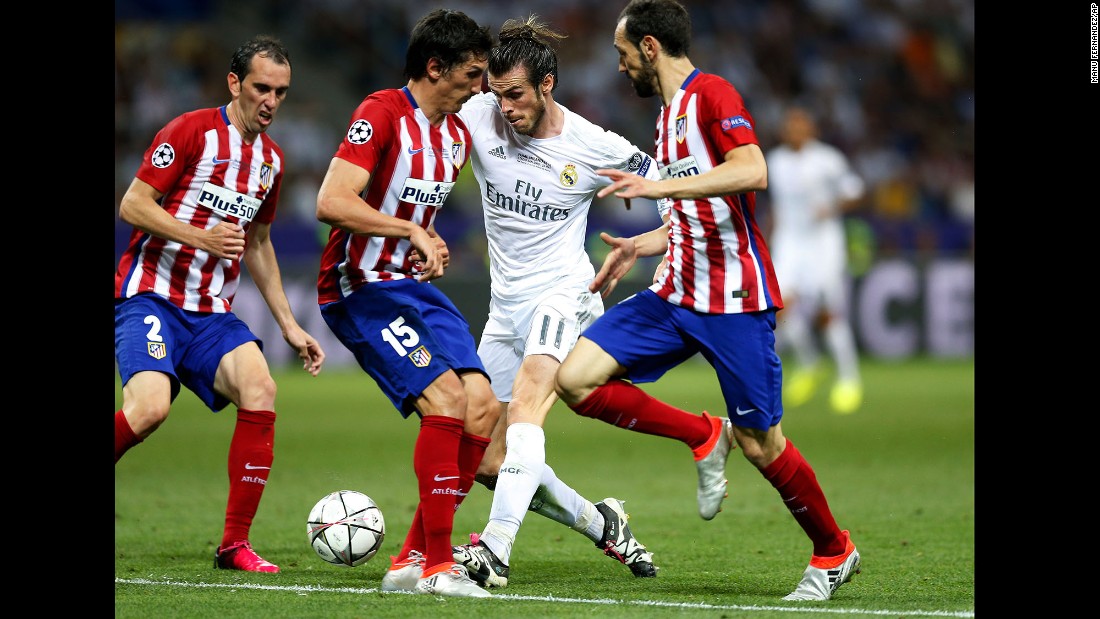 Real Madrid&#39;s Gareth Bale tries to maintain control of the ball while driving through some Atletico players. 