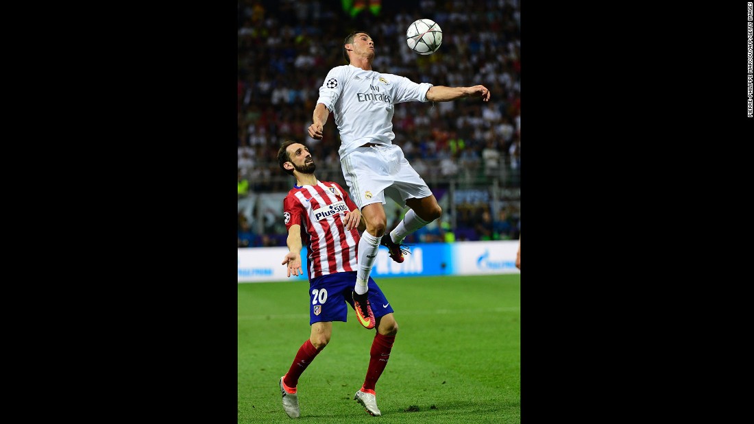 Real Madrid forward Cristiano Ronaldo heads the ball next to Atletico Madrid defender Juanfran.  