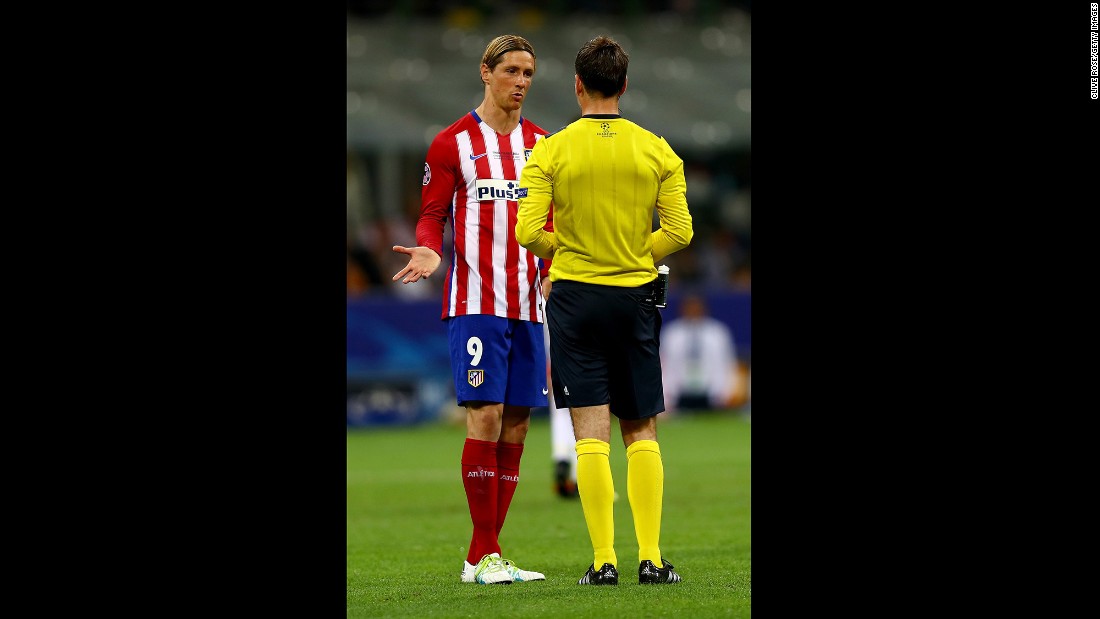 Fernando Torres of Atletico Madrid argues with referee Mark Clattenburg.