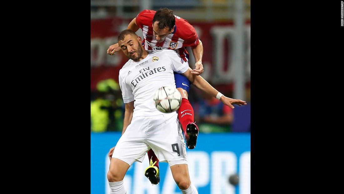 Atletico&#39;s Diego Godin challenges Real Madrid&#39;s Karim Benzema.
