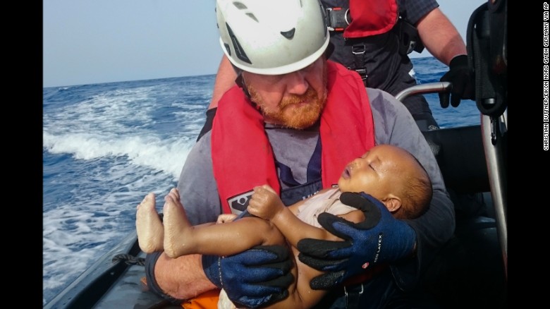 A member of the humanitarian organization Sea-Watch holds a migrant baby who drowned following the capsizing of a boat off Libya in May 2016.