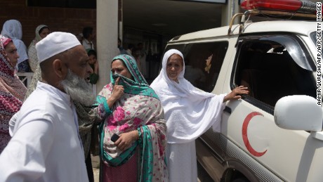 Pakistani relatives stand alongside an ambulance carrying Maria Abbasi, June 1, 2016.