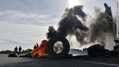 Union members stand next to tires set ablaze near an oil refinery this week in Donges. 