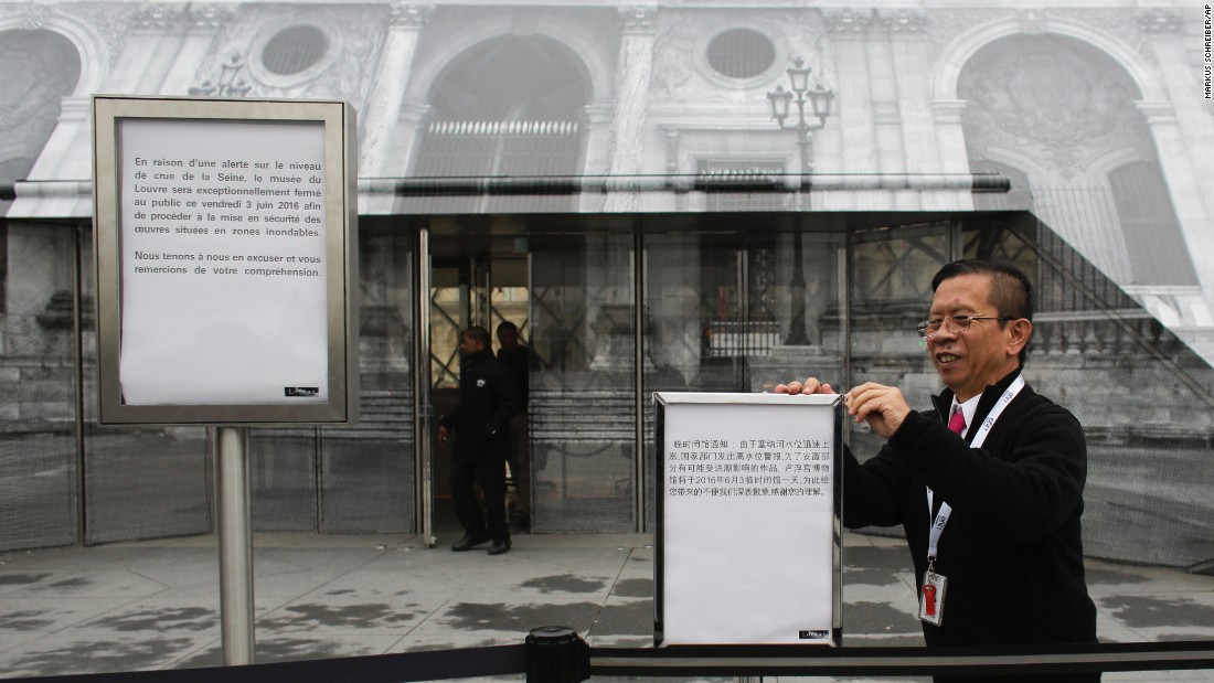 Staff of the Louvre post signs on June 3, informing visitors about the closing of the famous museum due to flooding in the city. 