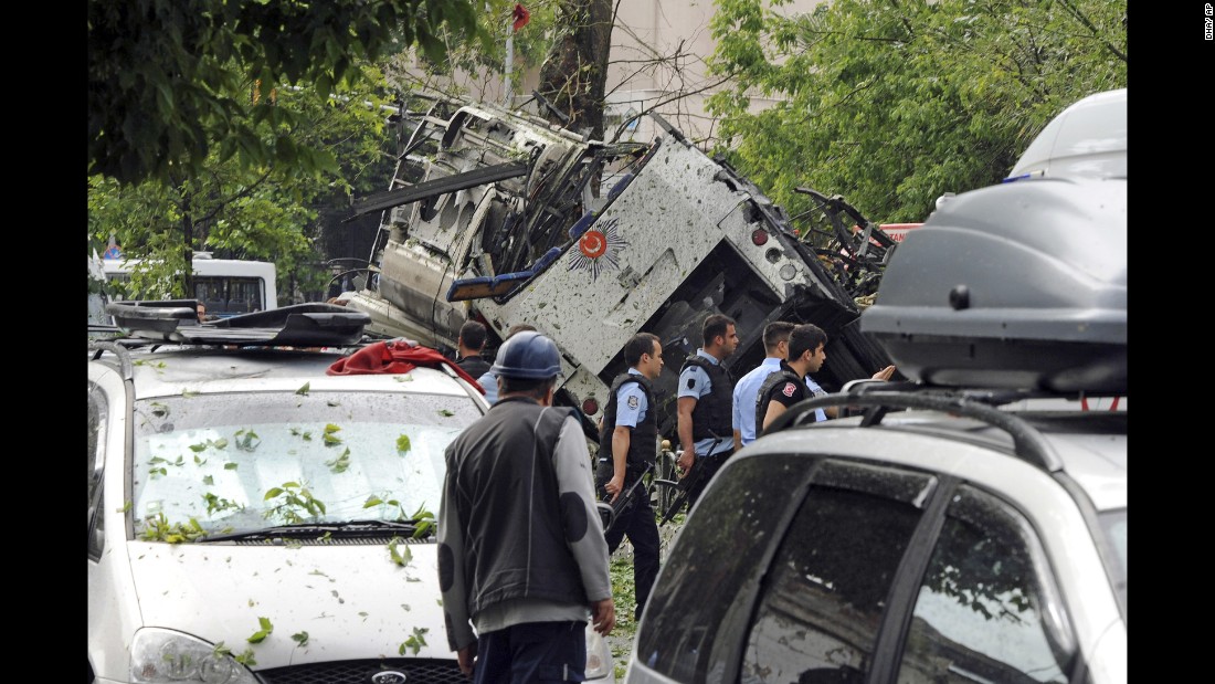 Security officials and firefighters work at the explosion site.