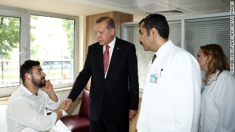 Turkish President Recep Tayyip Erdogan visits a man injured in the blast.
