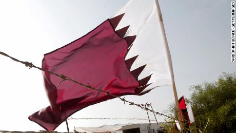 A Qatari flag flutters near a poster of Qatar&#39;s Emir Sheikh Hamad bin Khalifa al-Thani (L) at the construction site of a residential project funded by Qatar in Khan Yunis in the southern Gaza Strip on October 22, 2012. 