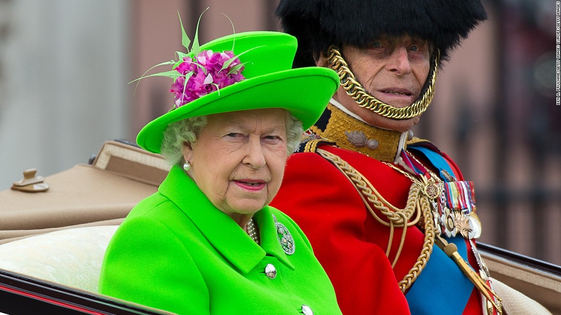 Queen Elizabeth II and Prince Philip, the Duke of Edinburgh, ride in an open carriage as they inspect the troops. 