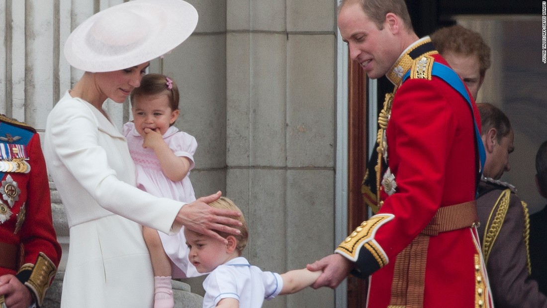 Catherine, Duchess of Cambridge, holds her daughter Princess Charlotte as Prince William, Duke of Cambridge, leads their son Prince George away from the balcony after watching a flypast of aircraft by the Royal Air Force.