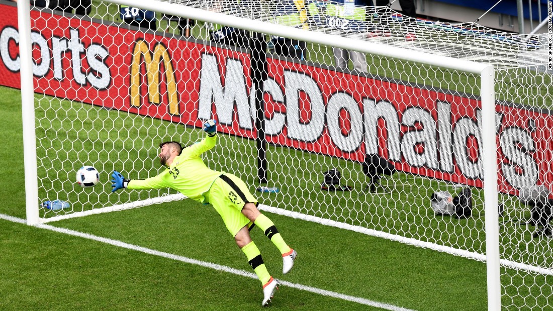 Matus Kozacik of Slovakia dives in vain as Gareth Bale scores a free kick goal.