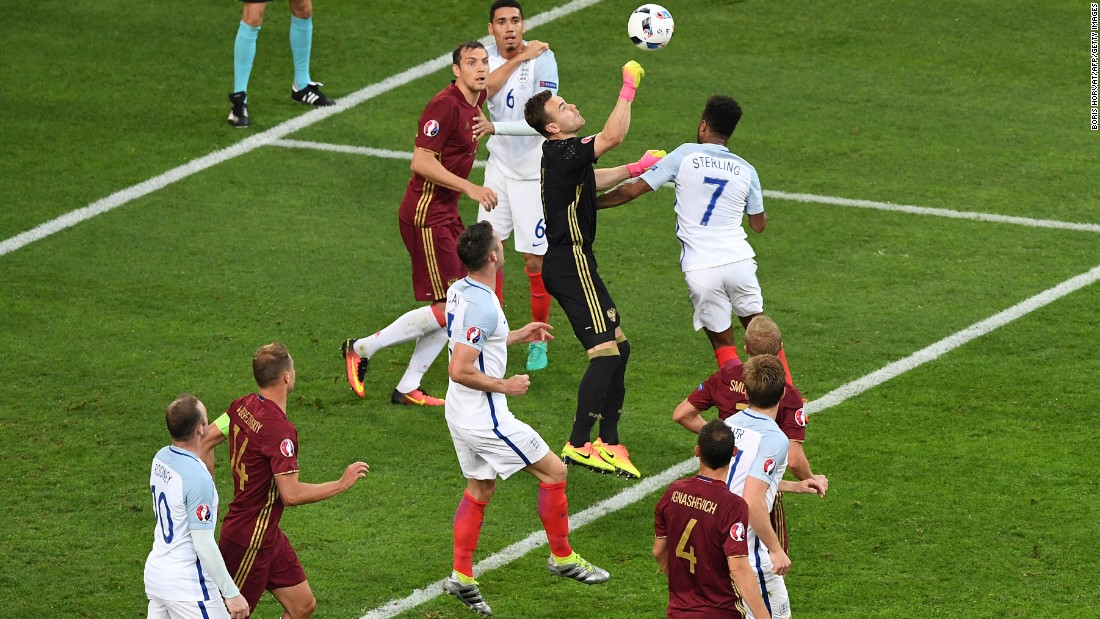 Russia goalkeeper Igor Akinfeev boxes the ball.