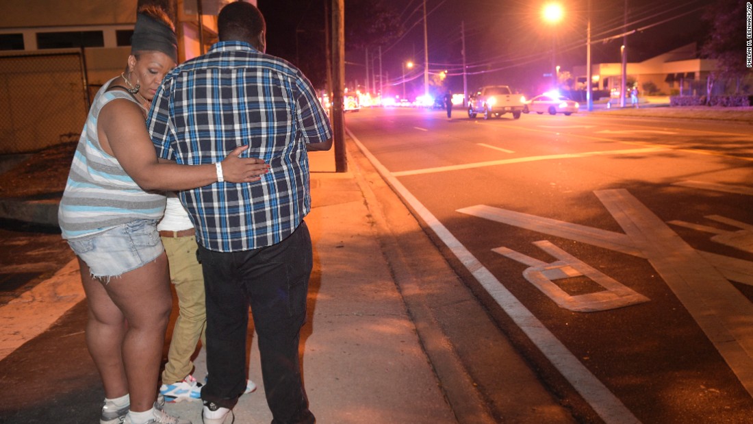 Bystanders wait at the scene.