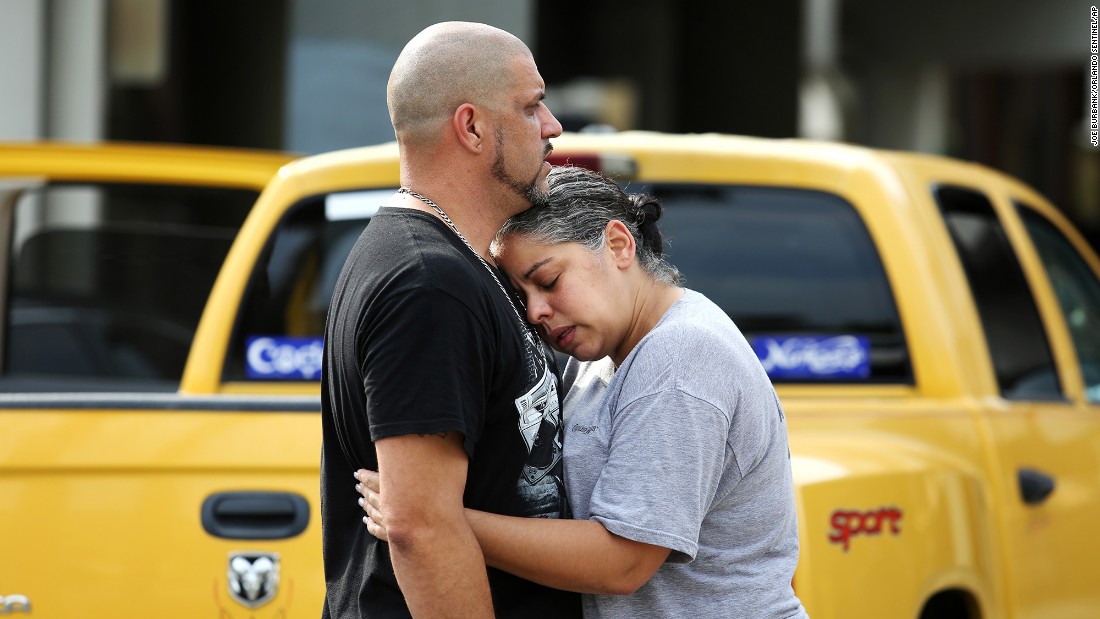 Ray Rivera, a DJ at the nightclub, is consoled by a friend outside of the Orlando Police Department.