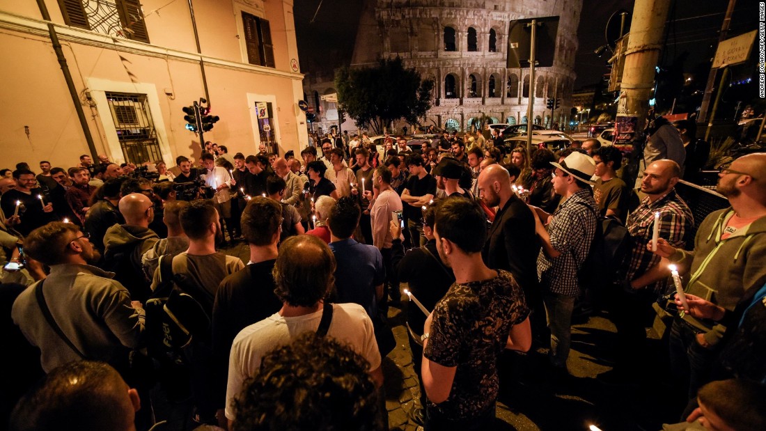 People hold candles near Rome&#39;s Colosseum as they take part in a ceremony on June 12.