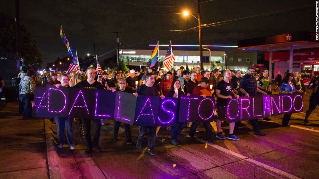 Mourners hold an LED sign as they march during a vigil in Dallas on Sunday, June 12.