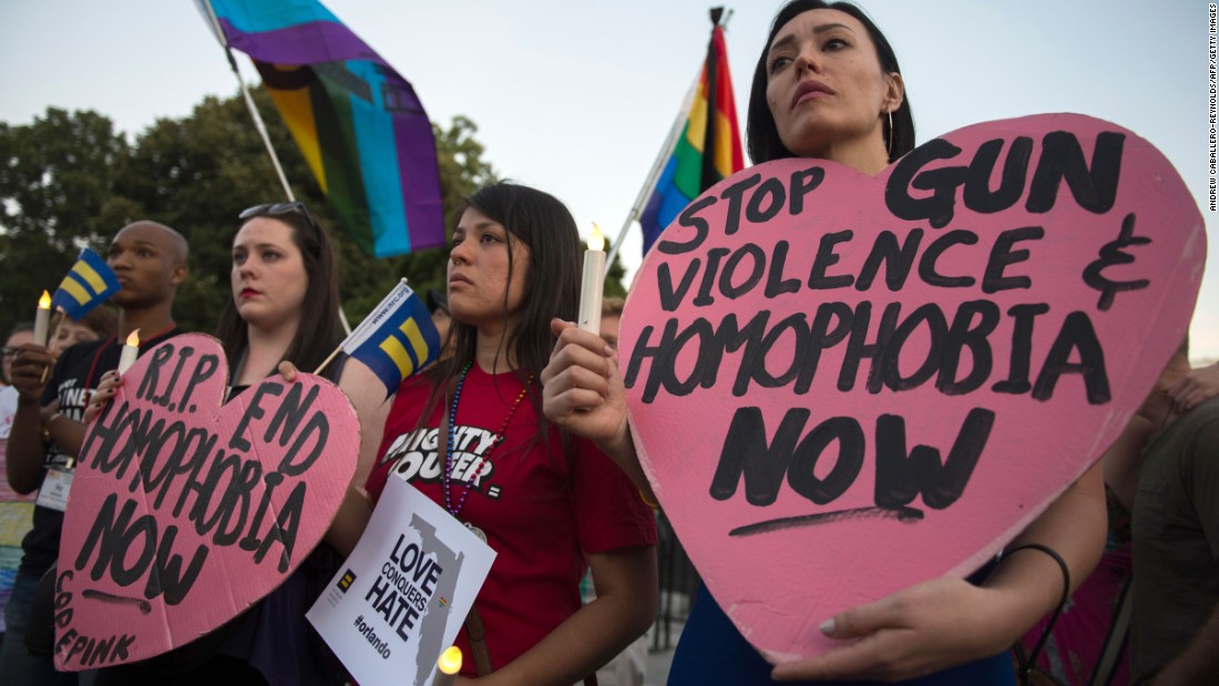 Mourners hold up signs during a vigil in Washington on June 12.