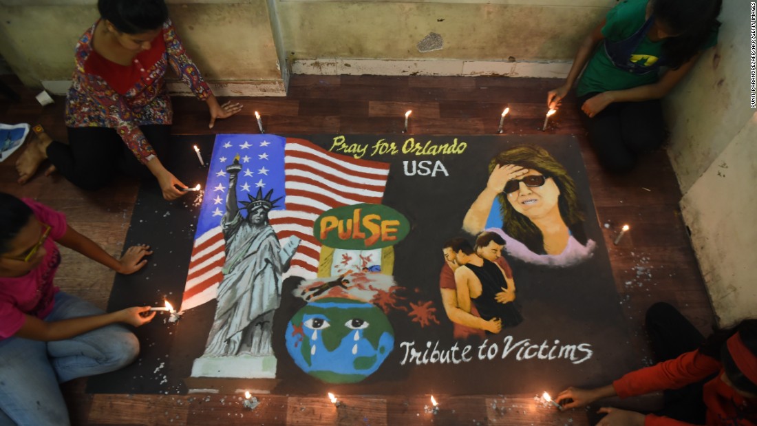 Students in Mumbai, India, light candles near a rangoli, an Indian form of art created on the ground, on June 13.