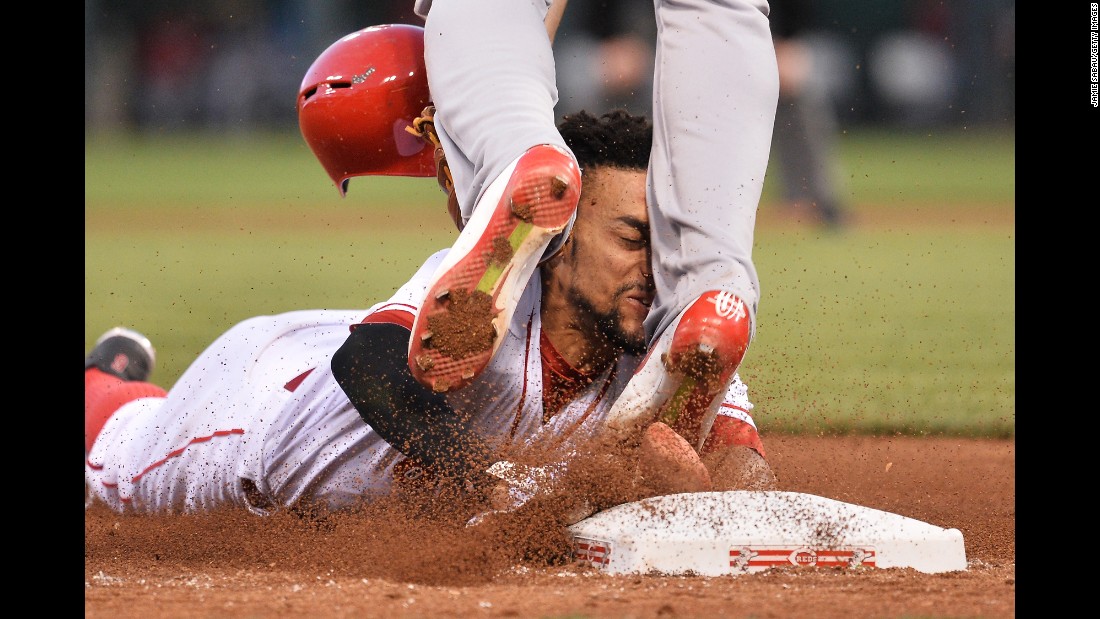 Cincinnati&#39;s Billy Hamilton slides into the legs of St. Louis&#39; Jhonny Peralta while trying to steal third base on Wednesday, June 8.
