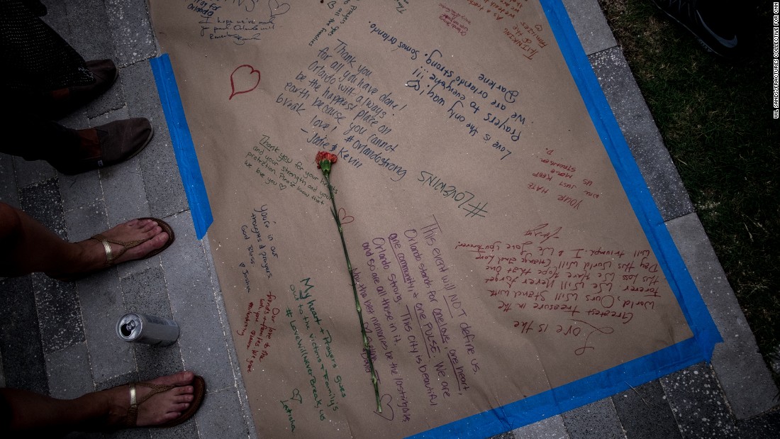 A flower is placed on a long sheet of paper adorned with heartfelt messages.