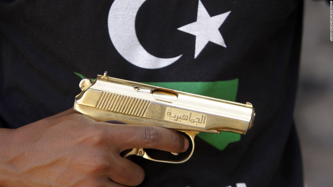 A Libyan fighter holds a golden gun found in the compound of Libya&#39;s ousted leader Moammar Gadhafi, in Bab al-Azizizyah, Tripoli, on September 25, 2011.