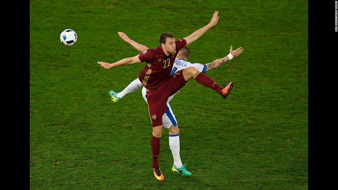 Slovakia&#39;s Jan Durica and Russia&#39;s Artem Dzyuba batlle for possession.