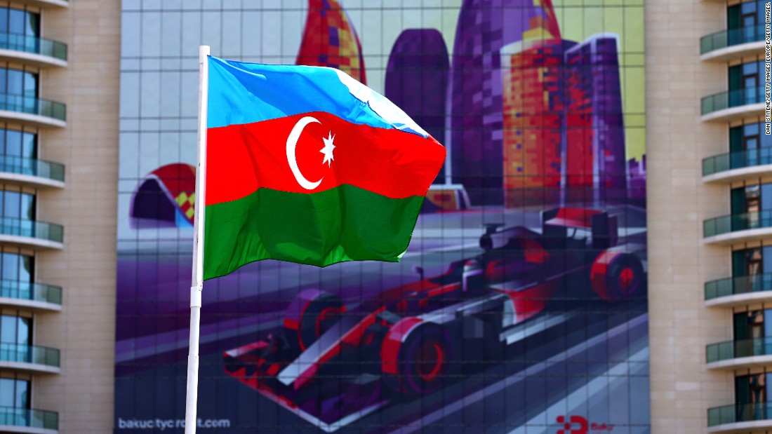 The Azerbaijan flag flutters in front of a poster promoting the European Grand Prix in Baku. 
