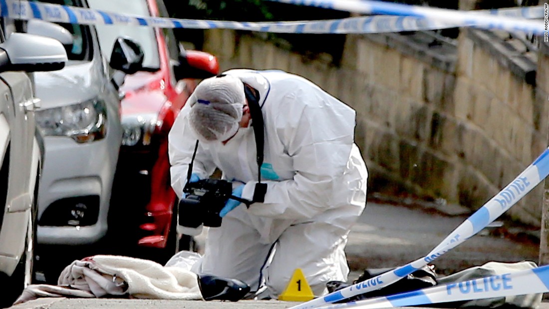 A forensics officer takes photos of items at the scene of the attack.