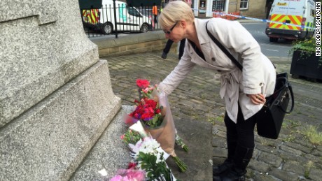 A mourner places flowers at Birstall&#39;s Market Square in honor of Jo Cox.
