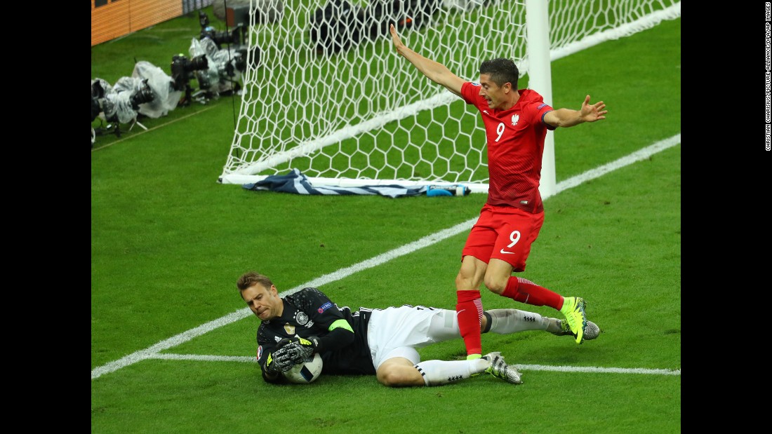 German goalkeeper Manuel Neuer collects the ball near Poland&#39;s star forward, Robert Lewandowski.