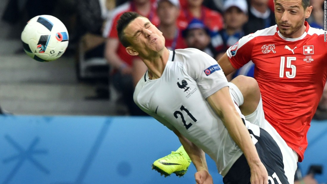 France&#39;s defender Laurent Koscielny heads the ball next to Switzerland&#39;s midfielder Blerim Dzemaili .