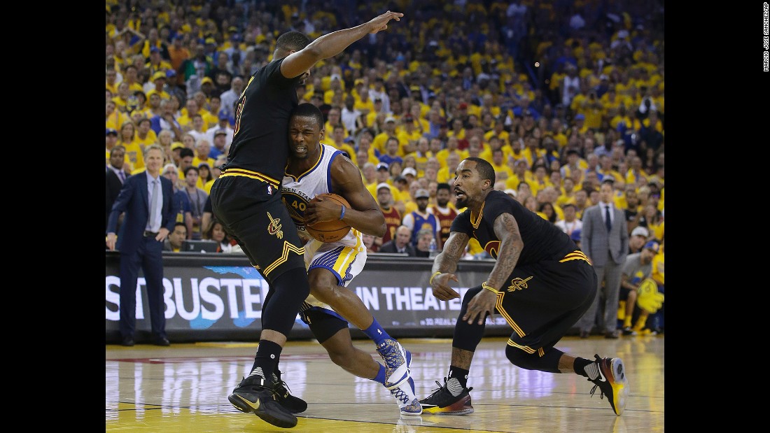 Warriors forward Harrison Barnes tries to drive past Cavaliers center Tristan Thompson, left, and guard J.R. Smith.