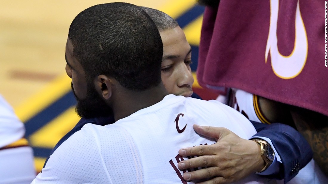 Head coach Tyronn Lue (in suit) hugs Kyrie Irving of the Cleveland Cavaliers in post-game celebration. Lue broke down in tears on the Cavaliers bench immediately after the game. 