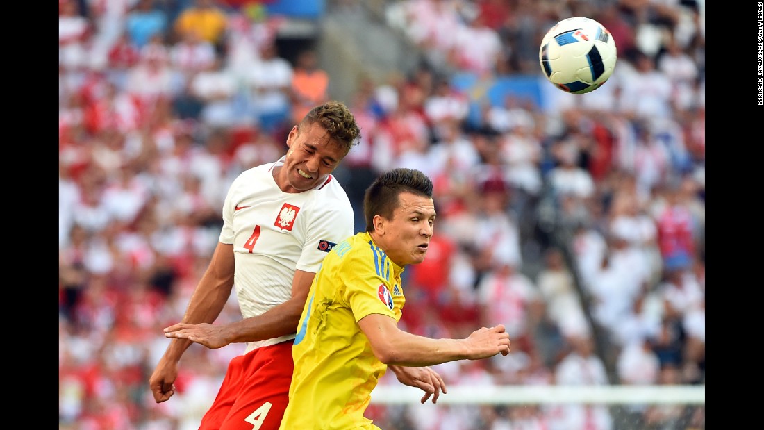 Polish defender Thiago Cionek, left, jumps for the ball with Ukrainian winger Yevhen Konoplyanka.