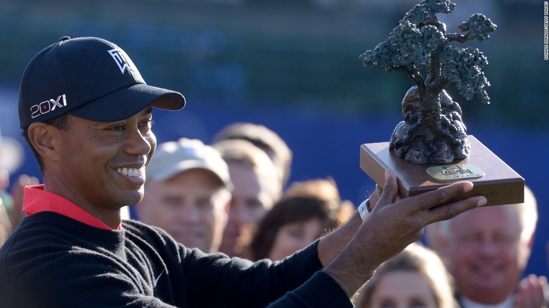 Woods holds the trophy for the Farmers Insurance Open at Torrey Pines in January 2013, where he clinched his 75th PGA Tour title. 