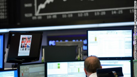 A trader sits  at his desk under the day&#39;s performance board that shows a dive in the value of the DAX index of companies at the Frankfurt Stock exchange the day after a majority of the British public voted for leaving the European Union on June 24, 2016 in Frankfurt am Main, Germany.