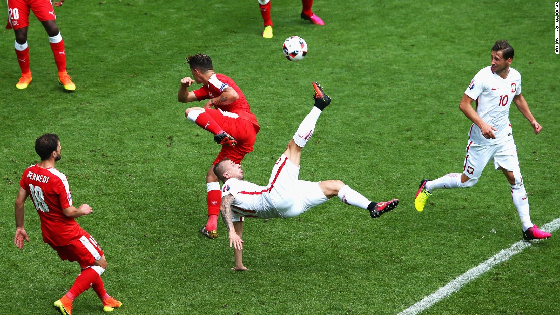 Kamil Grosicki of Poland attempts an overhead kick while Granit Xhaka of Switzerland tries to block.