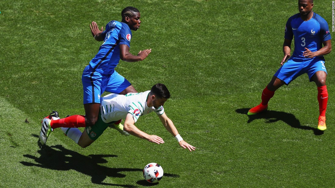 Shane Long of Ireland is challenged by Paul Pogba of France.