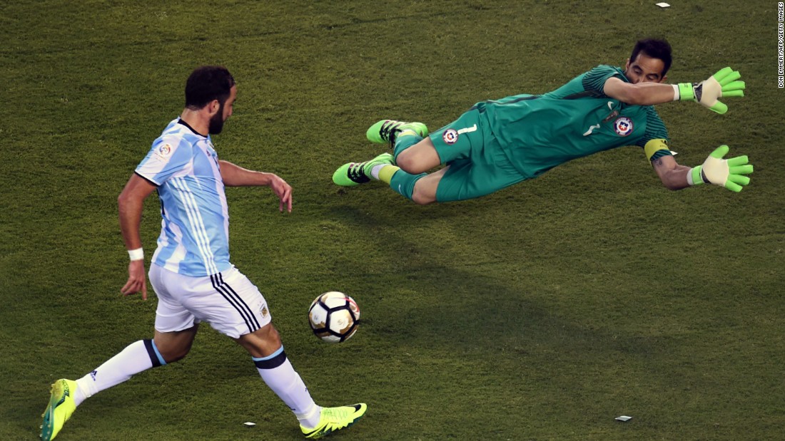 Argentina&#39;s Gonzalo Higuain, left,  prepares to shoot against Chile&#39;s goalie Claudio Bravo.