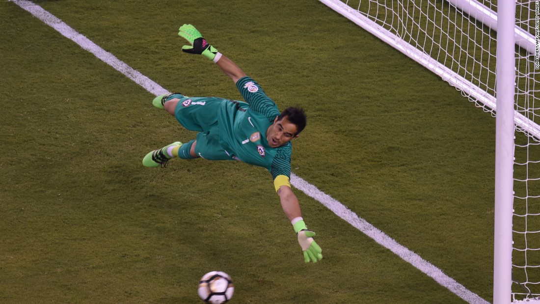 Chile&#39;s goalie Claudio Bravo fails to stop a shot by Argentina&#39;s Sergio Aguero, out of frame, during the penalty shoot-out.