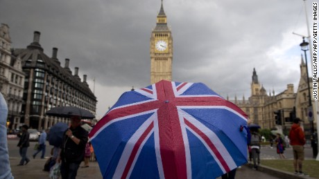 TOPSHOT - A pedestrian shelters from the rain beneath a Union flag themed umbrella as they walk near the Big Ben clock face and the Elizabeth Tower at the Houses of Parliament in central London on June 25, 2016, following the pro-Brexit result of the UK&#39;s EU referendum vote.
The result of Britain&#39;s June 23 referendum vote to leave the European Union (EU) has pitted parents against children, cities against rural areas, north against south and university graduates against those with fewer qualifications. London, Scotland and Northern Ireland voted to remain in the EU but Wales and large swathes of England, particularly former industrial hubs in the north with many disaffected workers, backed a Brexit. / AFP / JUSTIN TALLIS        (Photo credit should read JUSTIN TALLIS/AFP/Getty Images)