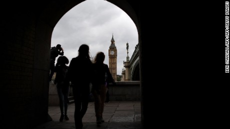 Pedestrians walk along the South Bank opposite the Big Ben clock face and the Elizabeth Tower at Houses of Parliament in central London on June 29, 2016.