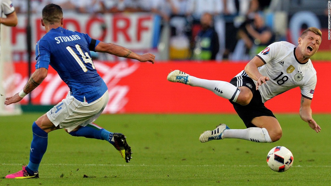 Italy midfielder Stefano Sturaro looks on as Germany midfielder Toni Kroos goes flying.
