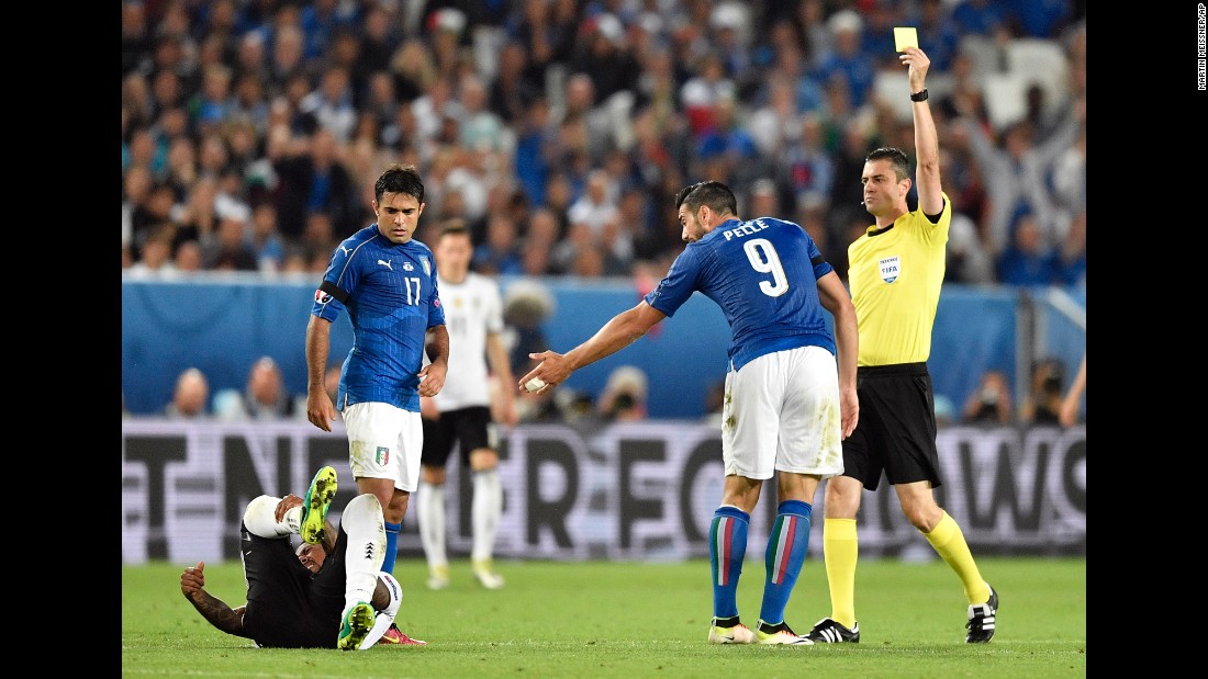 Referee Viktor Kassai shows a yellow card to Italy&#39;s Graziano Pelle. By the end of the match, Italy was given five yellow cards and Germany two.