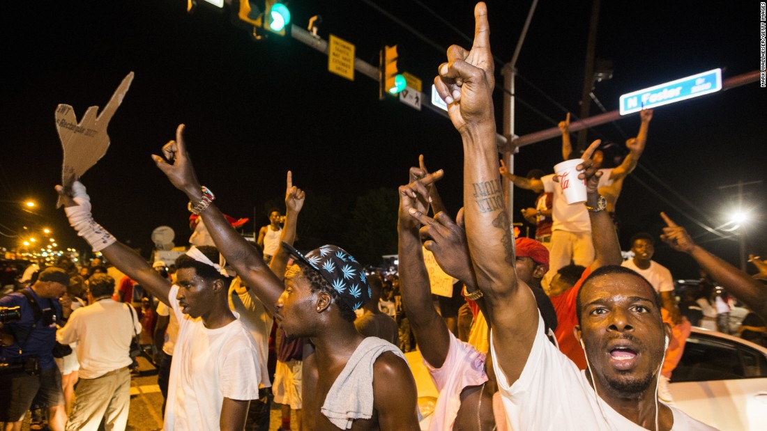 Protesters block traffic and dance on cars near the convenience store.